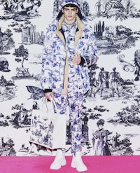 a man standing in front of a blue and white wallpaper