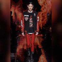 a man wearing red pants and a red jacket on the runway